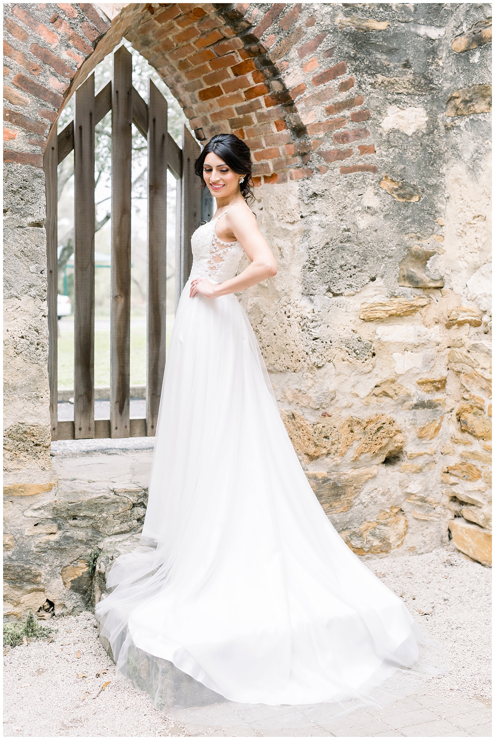 Bride showing off the side details to her wedding dress for her Spanish Missions Bridal Portraits in San Antonio, TX with Monica Roberts Photography | www.monicaroberts.com