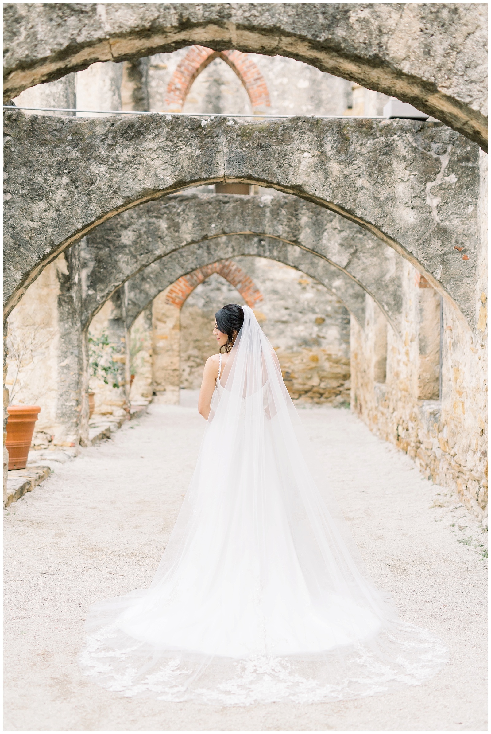 Bride showing off the back details to her wedding dress for her Spanish Missions Bridal Portraits in San Antonio, TX with Monica Roberts Photography | www.monicaroberts.com