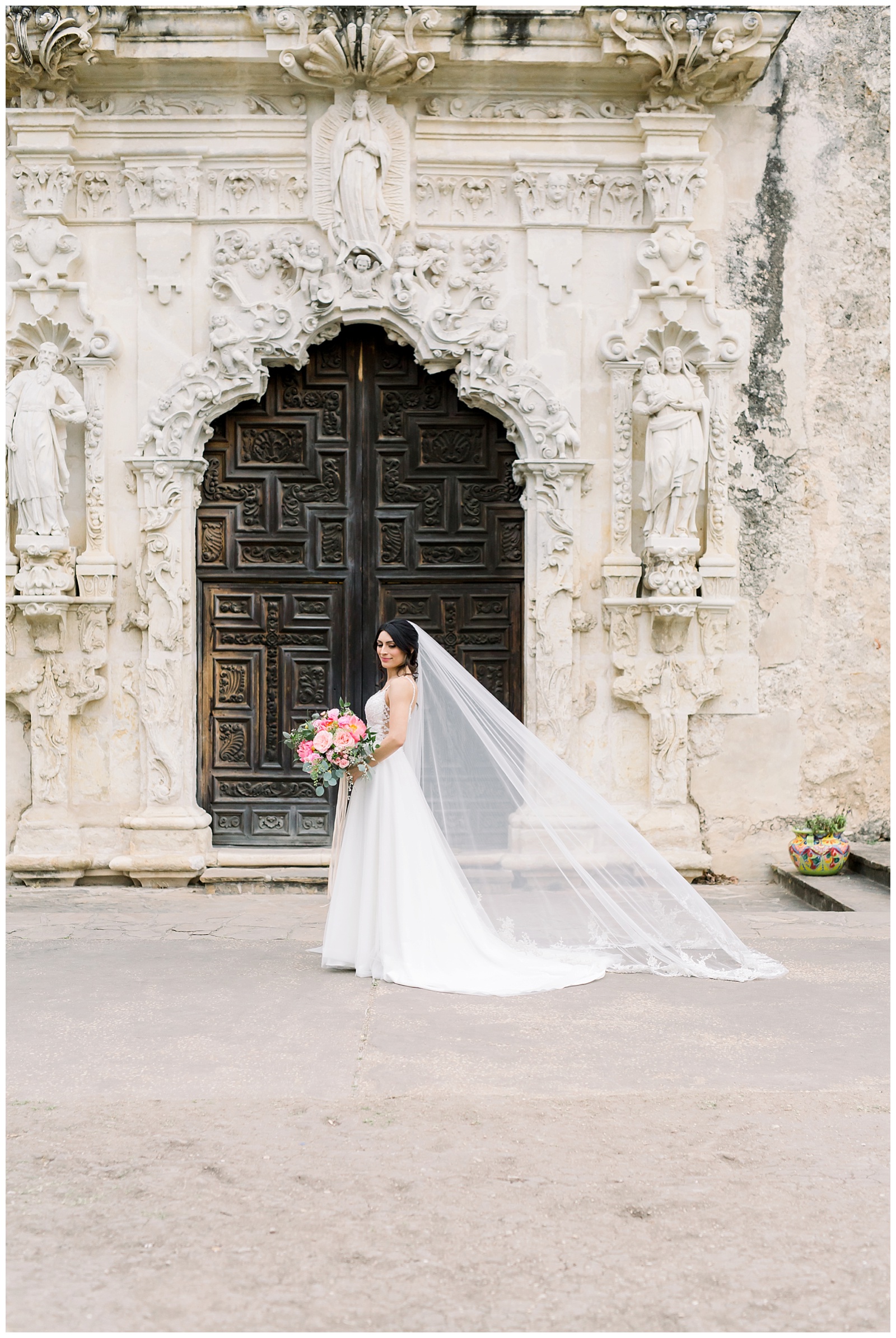 bride standing in front of spanish doors with veil for her Spanish Missions Bridal Portraits in San Antonio, TX with Monica Roberts Photography | www.monicaroberts.com