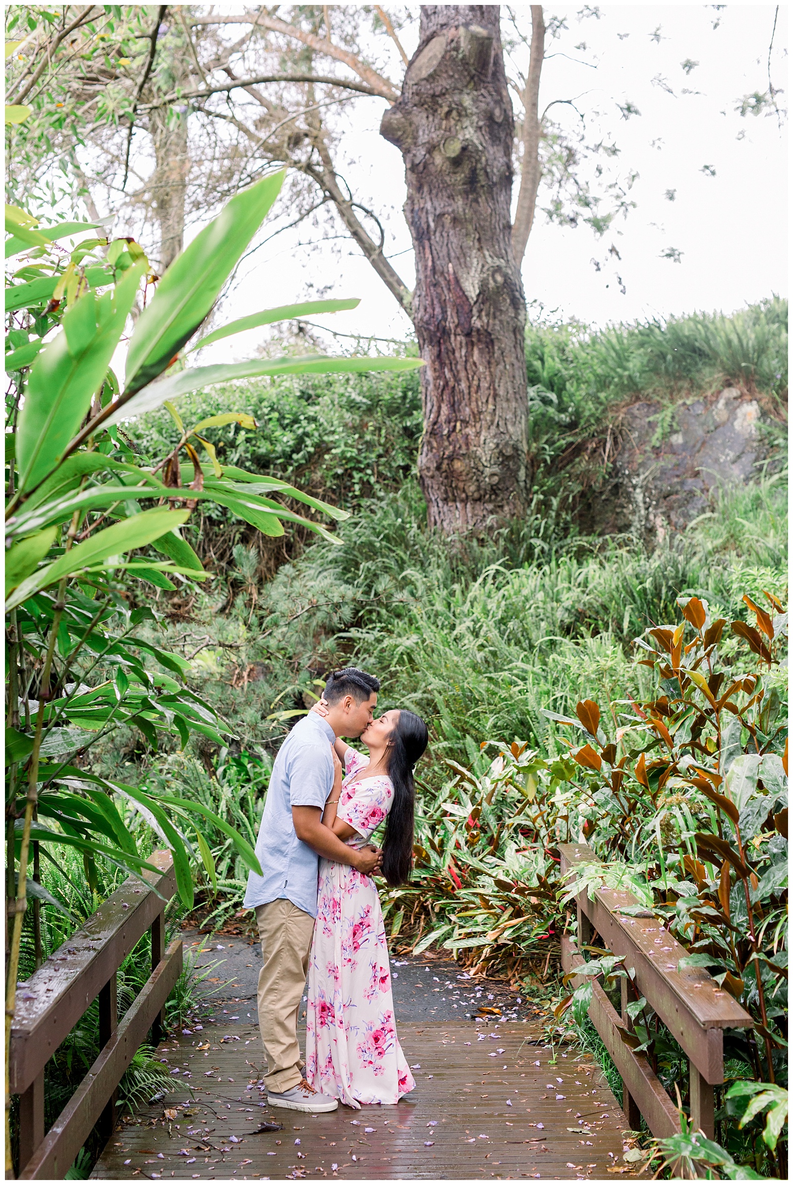 Couple embraces in romantic kiss on bridge surrounded by botanical gardens in Maui Hawaii Engagement-Kula Botanical Gardens Engagement - Ali'i Kula Lavendar Farm Engagement | Maui Hawaii and Destination, Engagement, Elopement and Wedding Photographer Monica Roberts Photography | www.monicaroberts.com