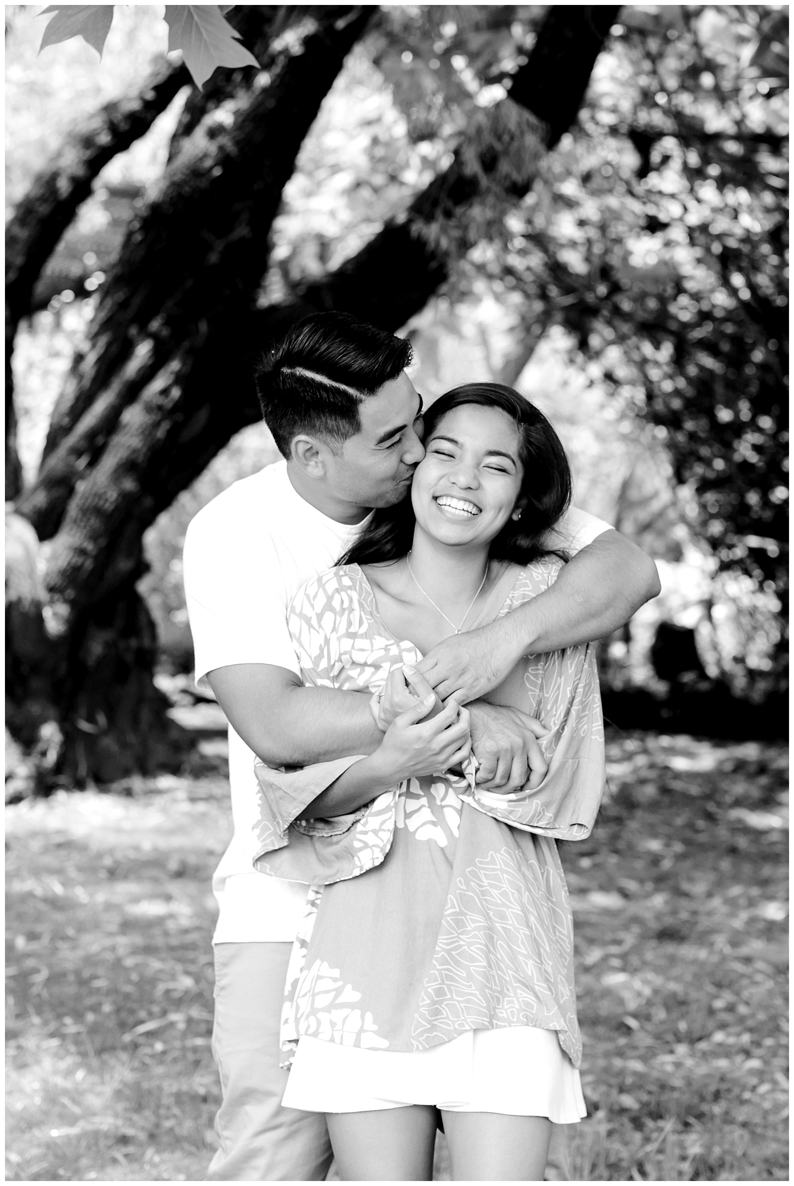 Black and white photo of male hugging his fiance from behind under a tree in Maui Hawaii Engagement Session-Kula Botanical Gardens Engagement - Ali'i Kula Lavendar Farm Engagement | Maui Hawaii and Destination, Engagement, Elopement and Wedding Photographer Monica Roberts Photography | www.monicaroberts.com