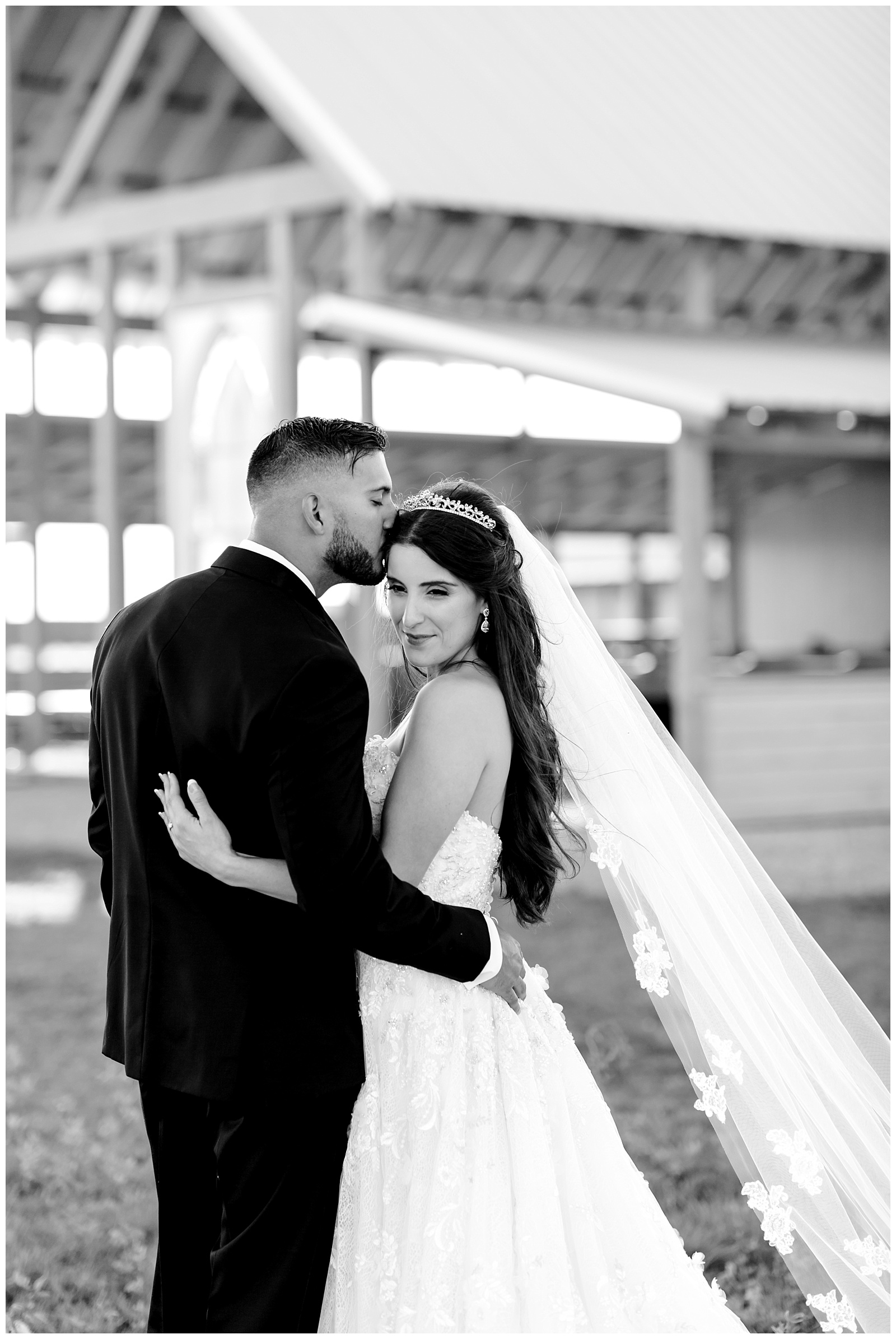 Black and white of groom sweetly kissing the bride on the forehead at The Allen Farmhaus Wedding, TX by San Antonio-Maui-Destination Wedding Photographer | Monica Roberts Photography | www.monicaroberts.com