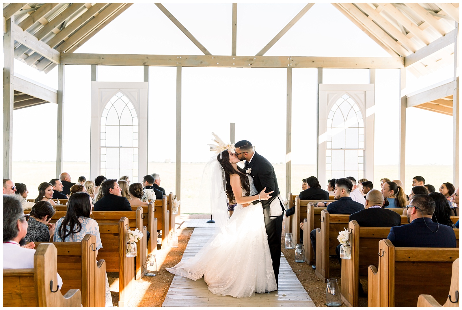 Gorgeous lighting with bride and groom kissing at alter at The Allen Farmhaus Wedding, TX by San Antonio-Maui-Destination Wedding Photographer | Monica Roberts Photography | www.monicaroberts.com