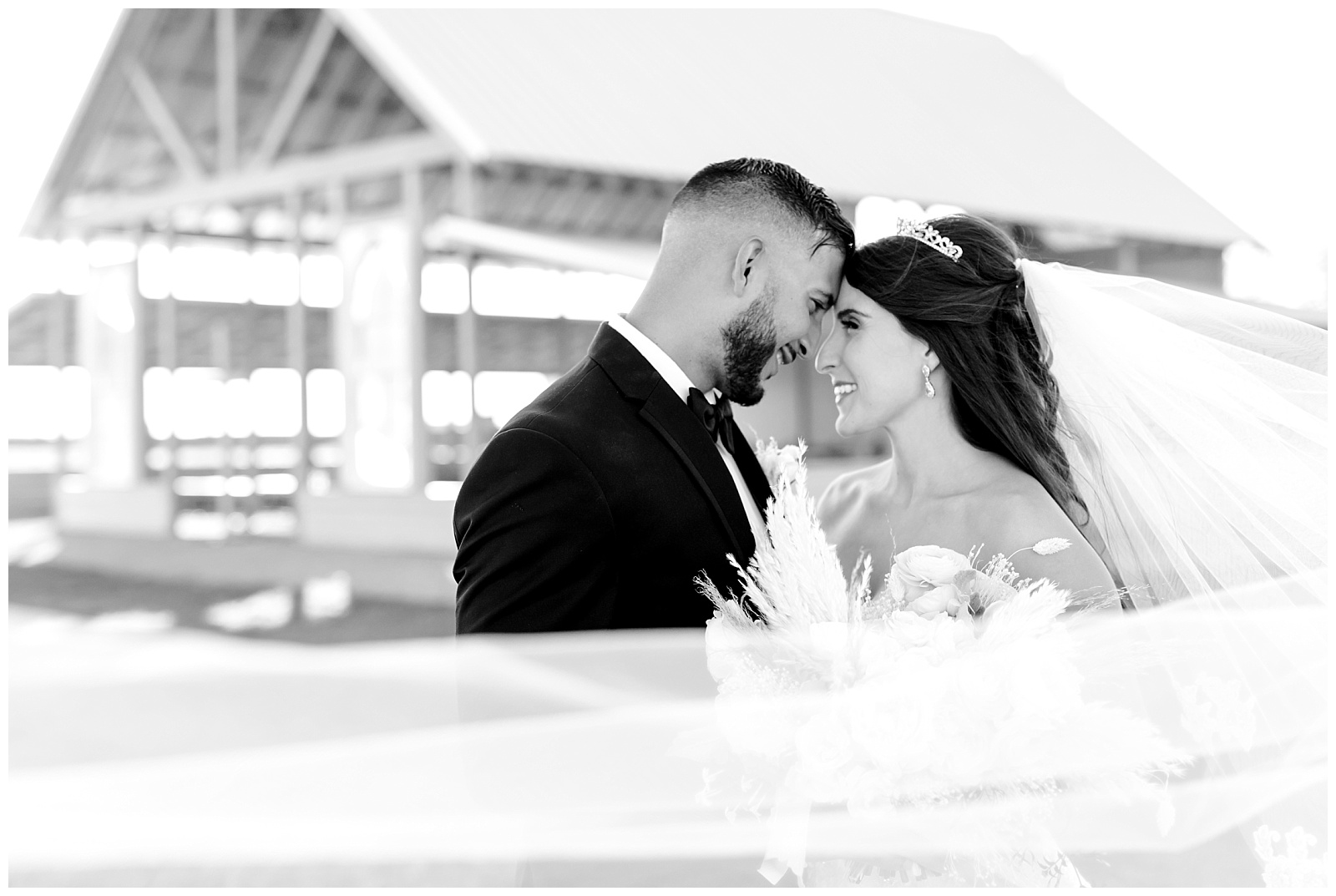Black and white of bride and groom nuzzling while veil sweeps in the wind around them at The Allen Farmhaus Wedding, TX by San Antonio-Maui-Destination Wedding Photographer | Monica Roberts Photography | www.monicaroberts.com