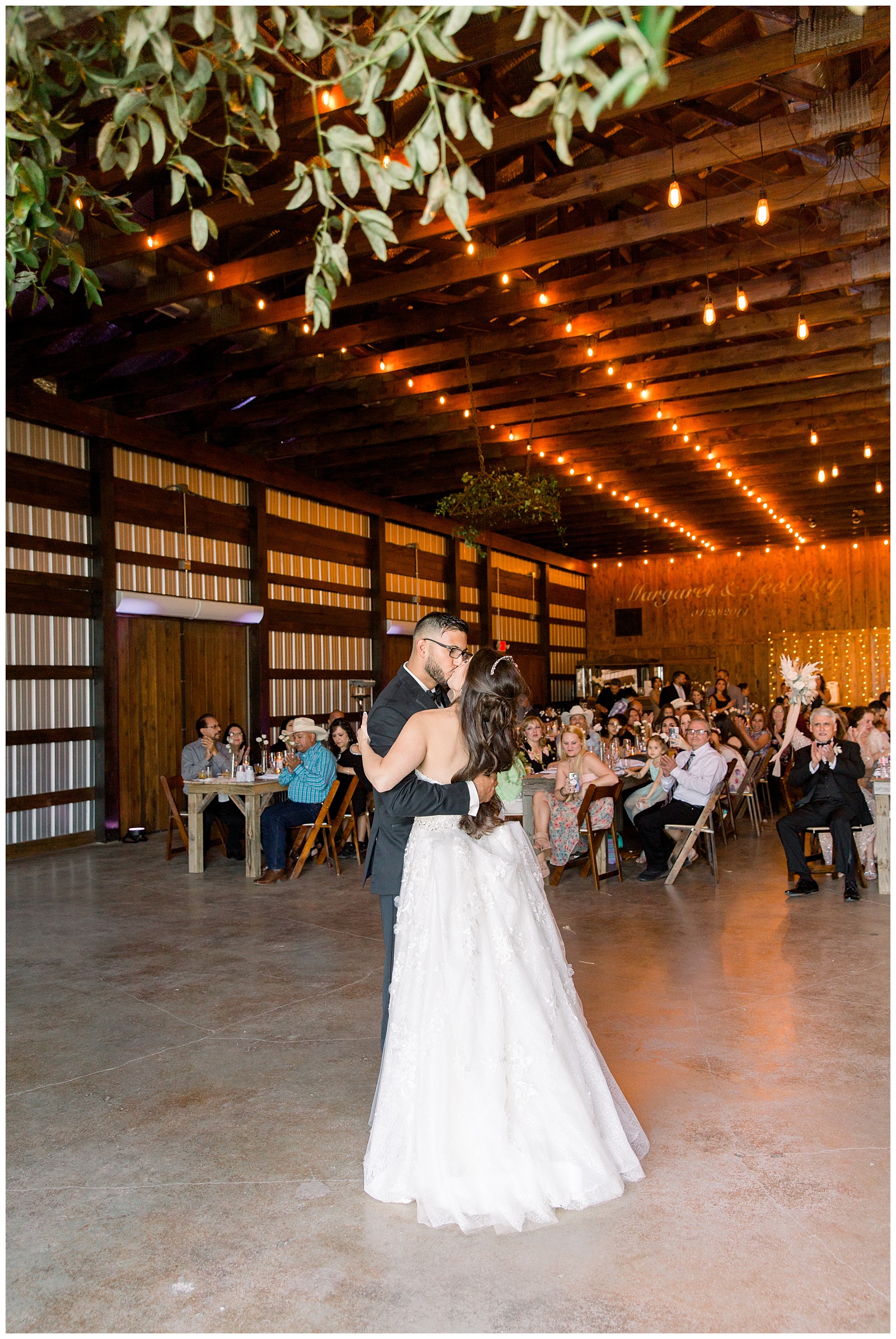 Bride and groom share a kiss during their first dance at The Allen Farmhaus Wedding, TX by San Antonio-Maui-Destination Wedding Photographer | Monica Roberts Photography | www.monicaroberts.com