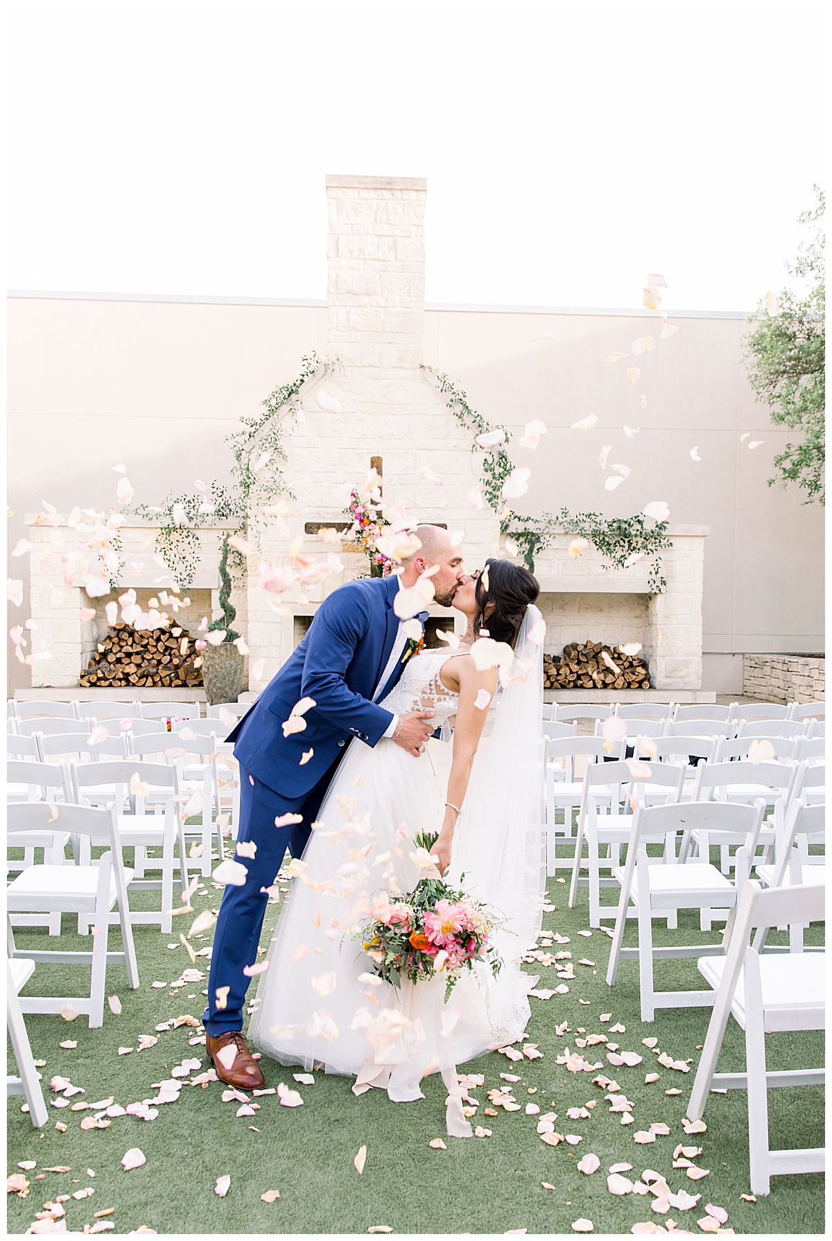 Bride and groom leaned over kissing while showered in rose petals in front of alter at Hyatt Regency Hill Country Resort Wedding in San Antonio, TX | San Antonio Wedding photographer| Destination Wedding Photographer| Monica Roberts Photography | monicaroberts.com