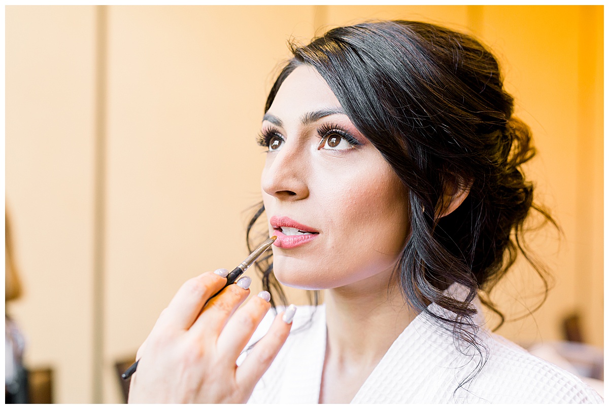 Bride getting makeup applied to her lips while getting ready at Hyatt Regency Hill Country Resort Wedding in San Antonio, TX | San Antonio Wedding photographer| Destination Wedding Photographer| Monica Roberts Photography | monicaroberts.com