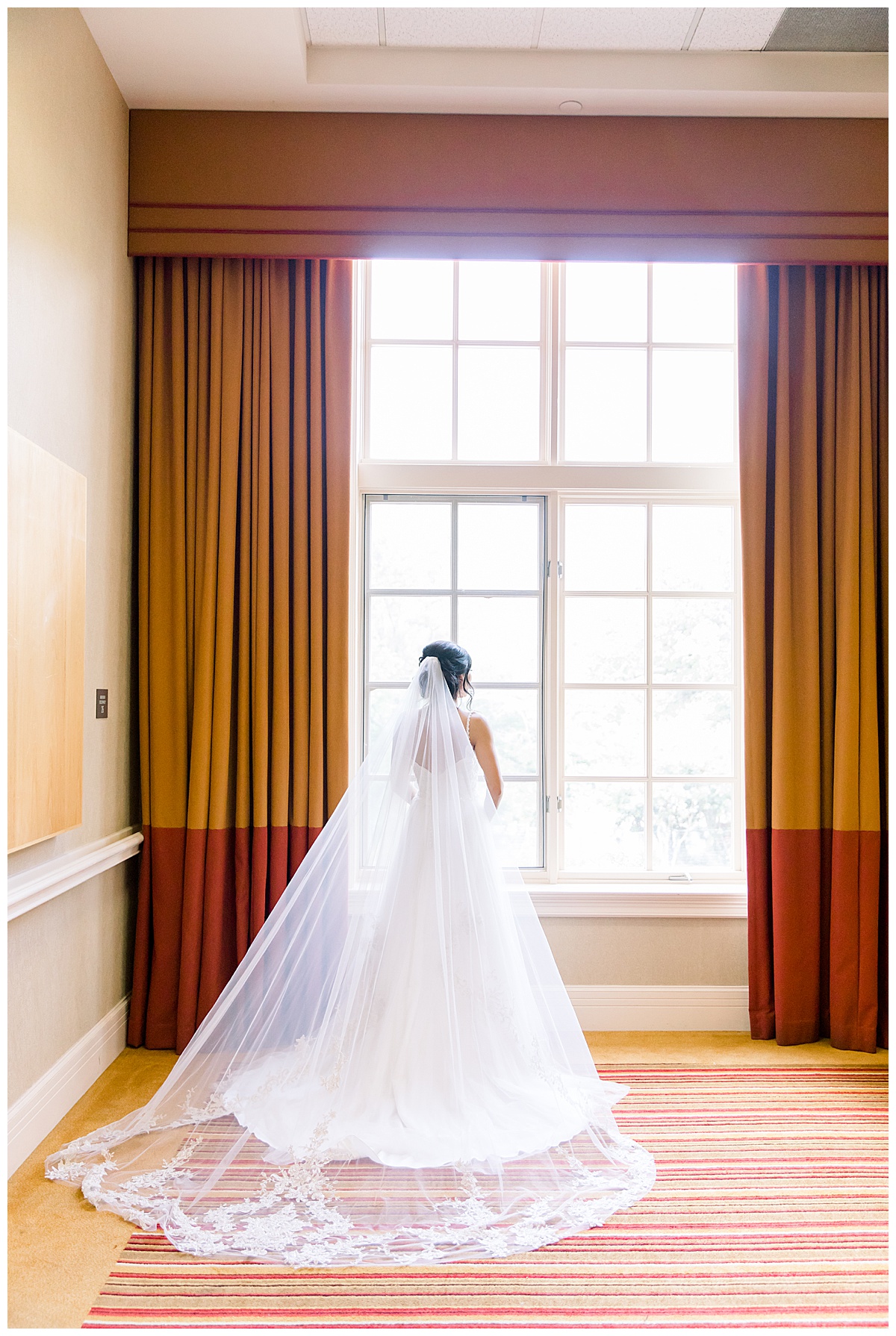 Bride standing in front of large window in the lighting with veil and train flowing out behind her at Hyatt Regency Hill Country Resort Wedding in San Antonio, TX | San Antonio Wedding photographer| Destination Wedding Photographer| Monica Roberts Photography | monicaroberts.com