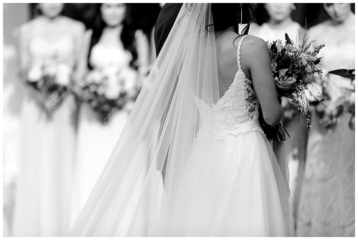 Black and white shot of back of bride's dress and veil as she stands at alter at Hyatt Regency Hill Country Resort Wedding in San Antonio, TX | San Antonio Wedding photographer| Destination Wedding Photographer| Monica Roberts Photography | monicaroberts.com