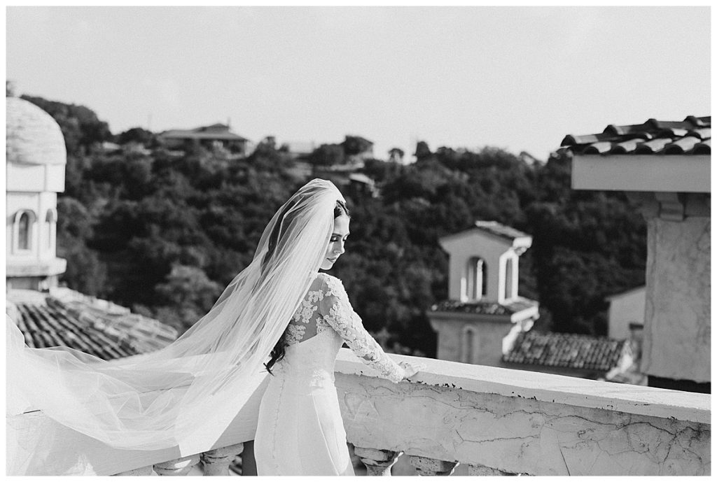 Black and white of bride looking over terrace with wind blowing veil back| Villa Antonia bridal session| Austin, TX wedding photographer| www.monicaroberts.com
