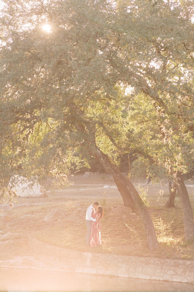 couple standing under a tree in front of a lake with golden light for a Romantic Engagement session at Kendall Plantation with Monica Roberts Photography www.monicaroberts.com