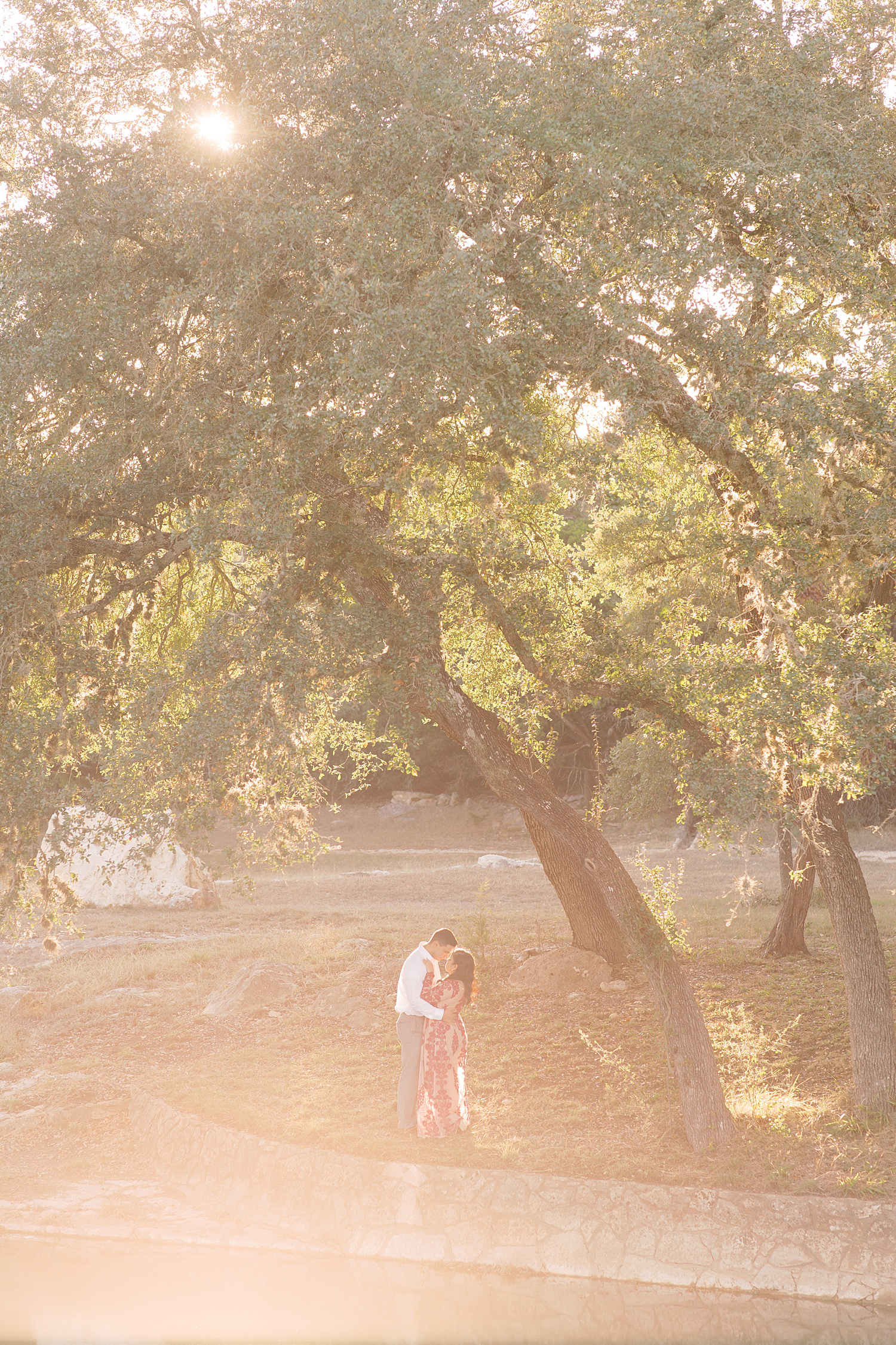 couple standing under a tree in front of a lake with golden light for a Romantic Engagement session at Kendall Plantation with Monica Roberts Photography www.monicaroberts.com