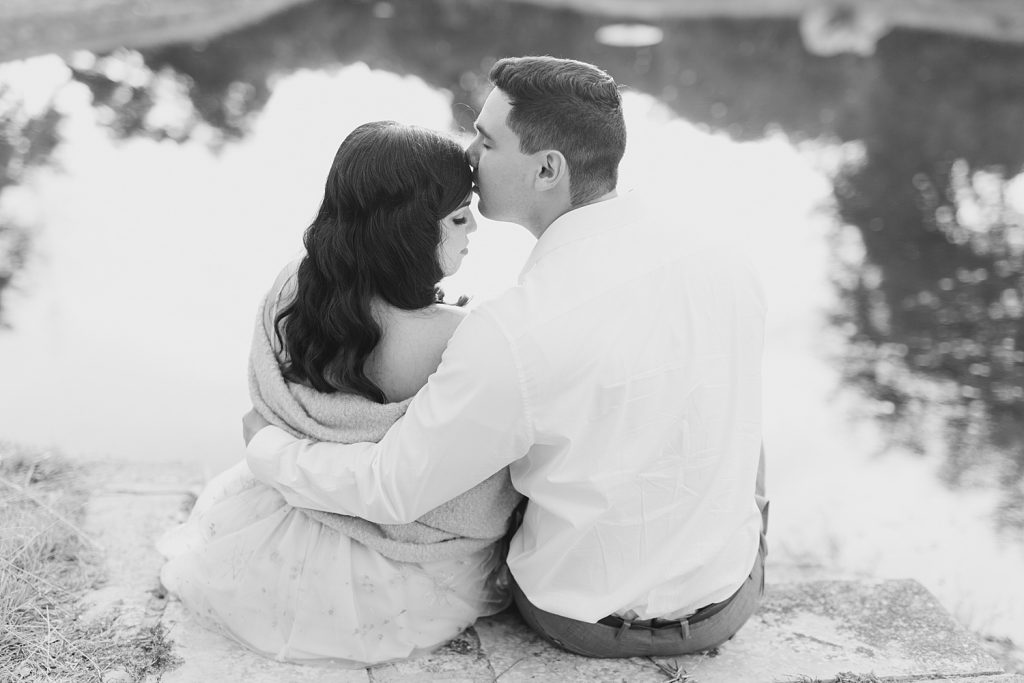black and white photograph of groom kissing his bride on the forehead for a Romantic Engagement session at Kendall Plantation with Monica Roberts Photography www.monicaroberts.com