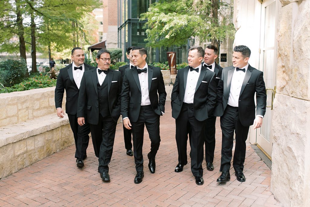 groom walking downtown with his groomsmen for a wedding at the Jack Guenther Pavilion at the Briscoe in San Antonio with Monica Roberts Photography - https://monicaroberts.com/