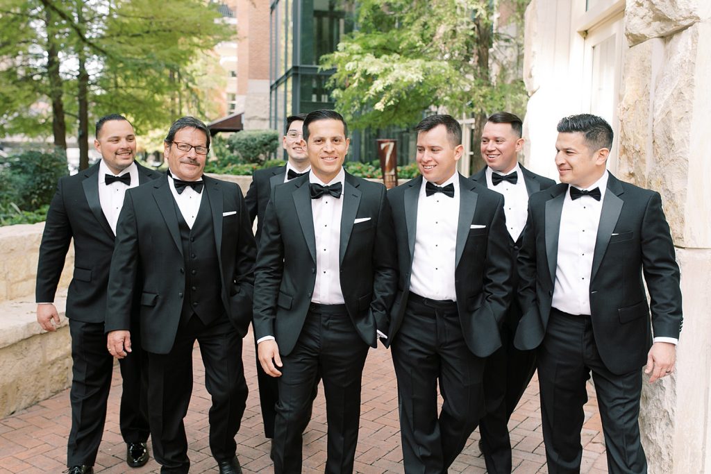 groom walking with his groomsmen for a wedding at the Jack Guenther Pavilion at the Briscoe in San Antonio with Monica Roberts Photography - https://monicaroberts.com/