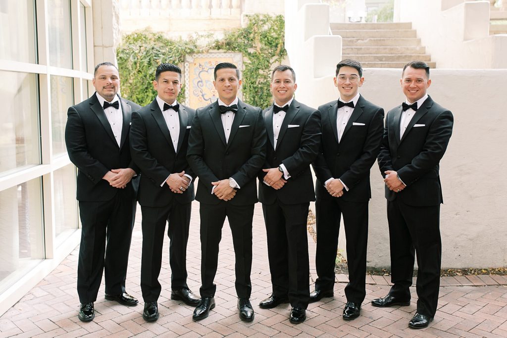 groom standing with groomsmen for a wedding at the Jack Guenther Pavilion at the Briscoe in San Antonio with Monica Roberts Photography - https://monicaroberts.com/