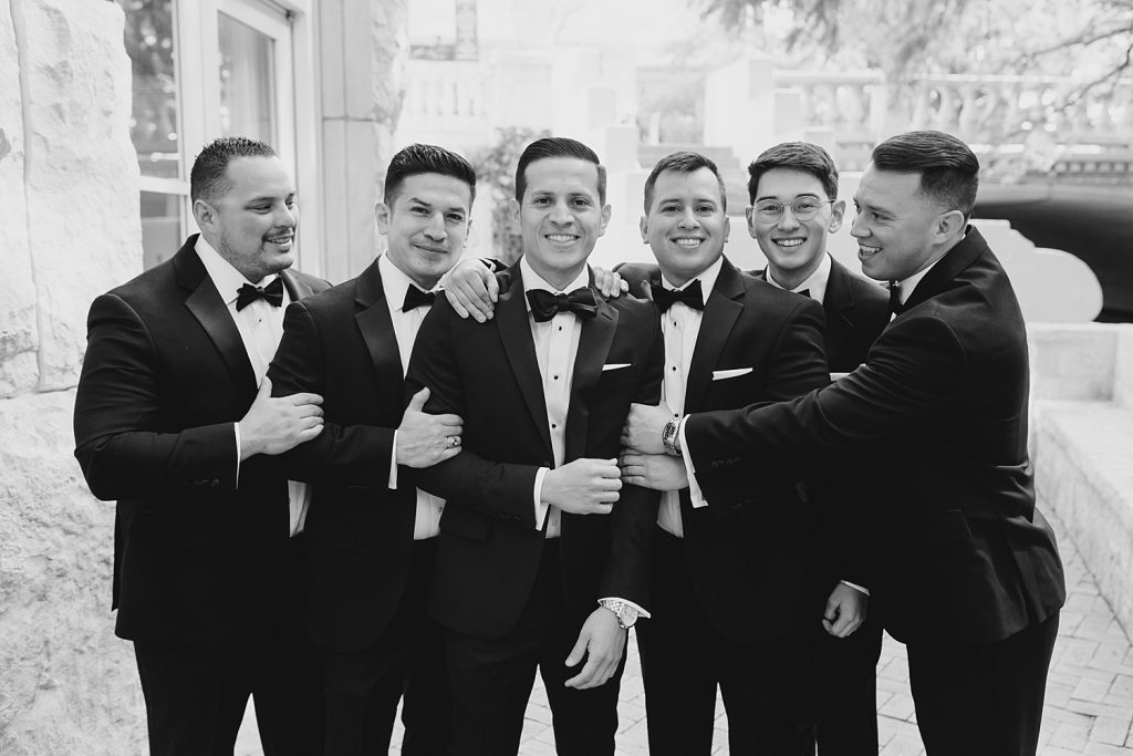 black and white photo of groom with groomsmen for a wedding at the Jack Guenther Pavilion at the Briscoe in San Antonio with Monica Roberts Photography - https://monicaroberts.com/