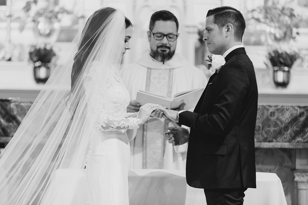 timeless black and white photo of couple exchanging rings for a wedding at the Jack Guenther Pavilion at the Briscoe in San Antonio with Monica Roberts Photography - https://monicaroberts.com/