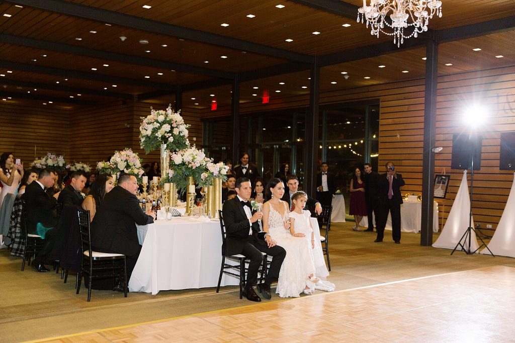 bride and groom sitting together while listening to speeches for a wedding at the Jack Guenther Pavilion at the Briscoe in San Antonio with Monica Roberts Photography - https://monicaroberts.com/