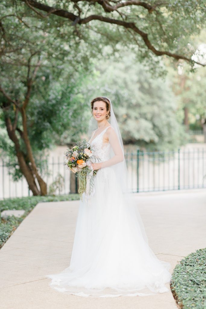 bride standing under a tree for a gorgeous outdoor garden wedding at The Guenther House in San Antonio, TX | Monica Roberts Photography | www.monicaroberts.com