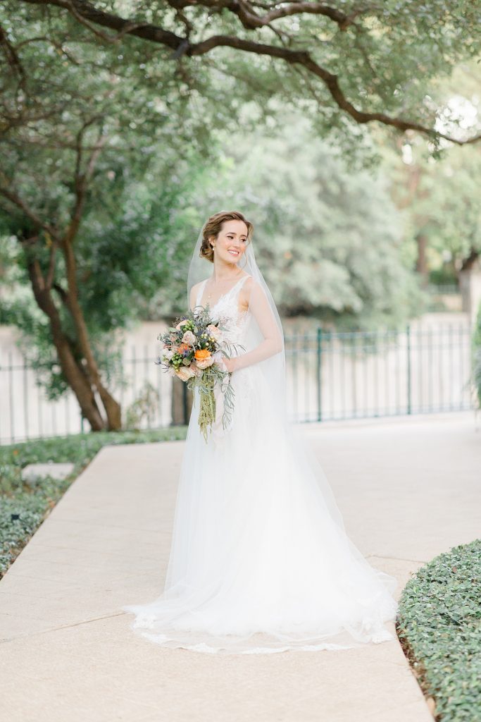 bride smiling over her shoulder for a gorgeous outdoor garden wedding at The Guenther House in San Antonio, TX | Monica Roberts Photography | www.monicaroberts.com