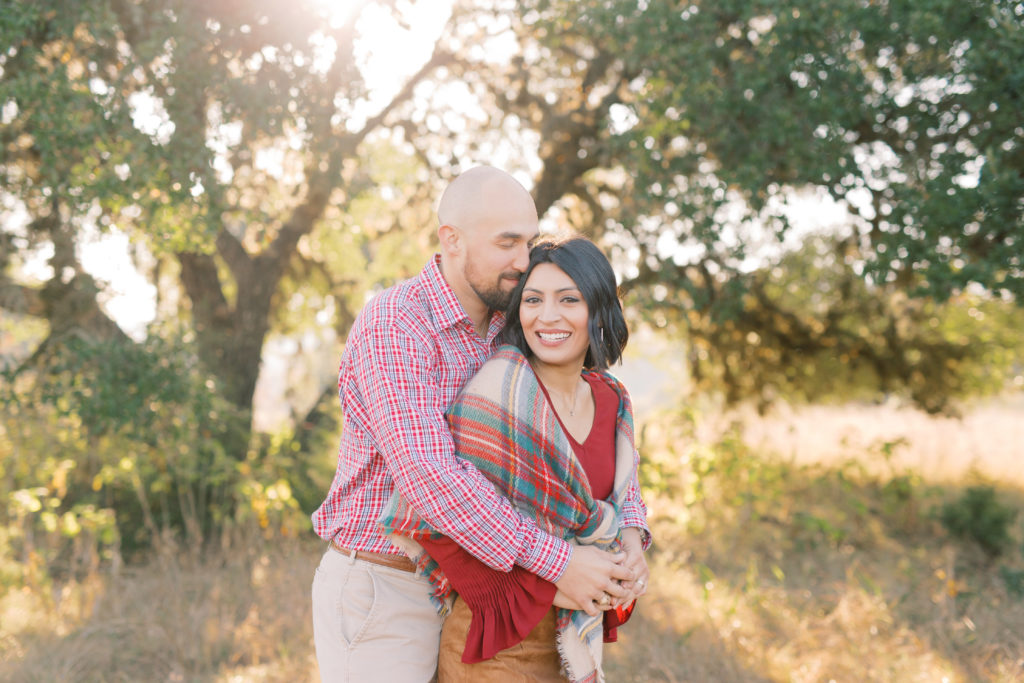 Husband nuzzles with this wife in a field with beautiful golden sun for a holiday mini session with Monica Roberts Photographer in Stafford, VA Wedding Photographer