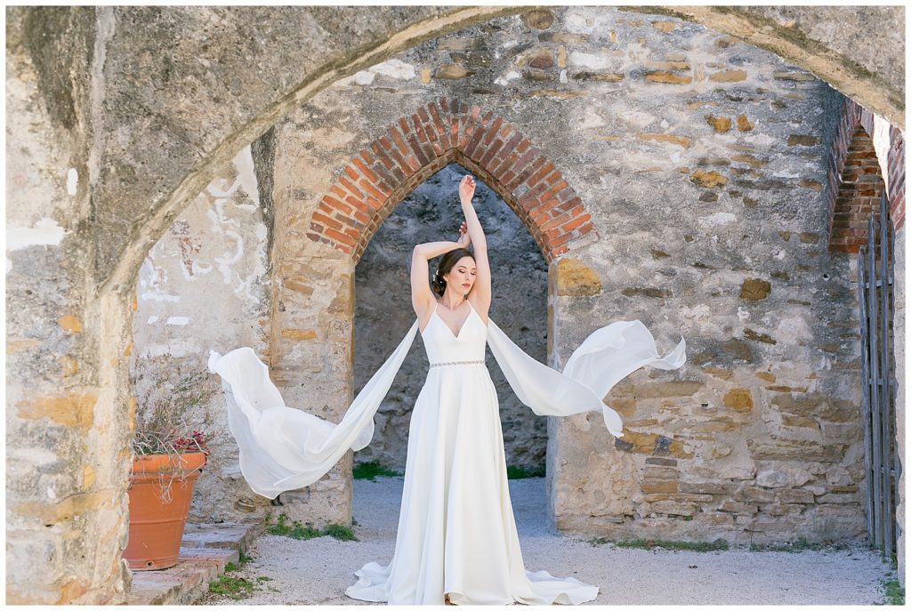 bride walking as the wings on her wedding dress flow in the wind for her bridals in Richmond, Virginia