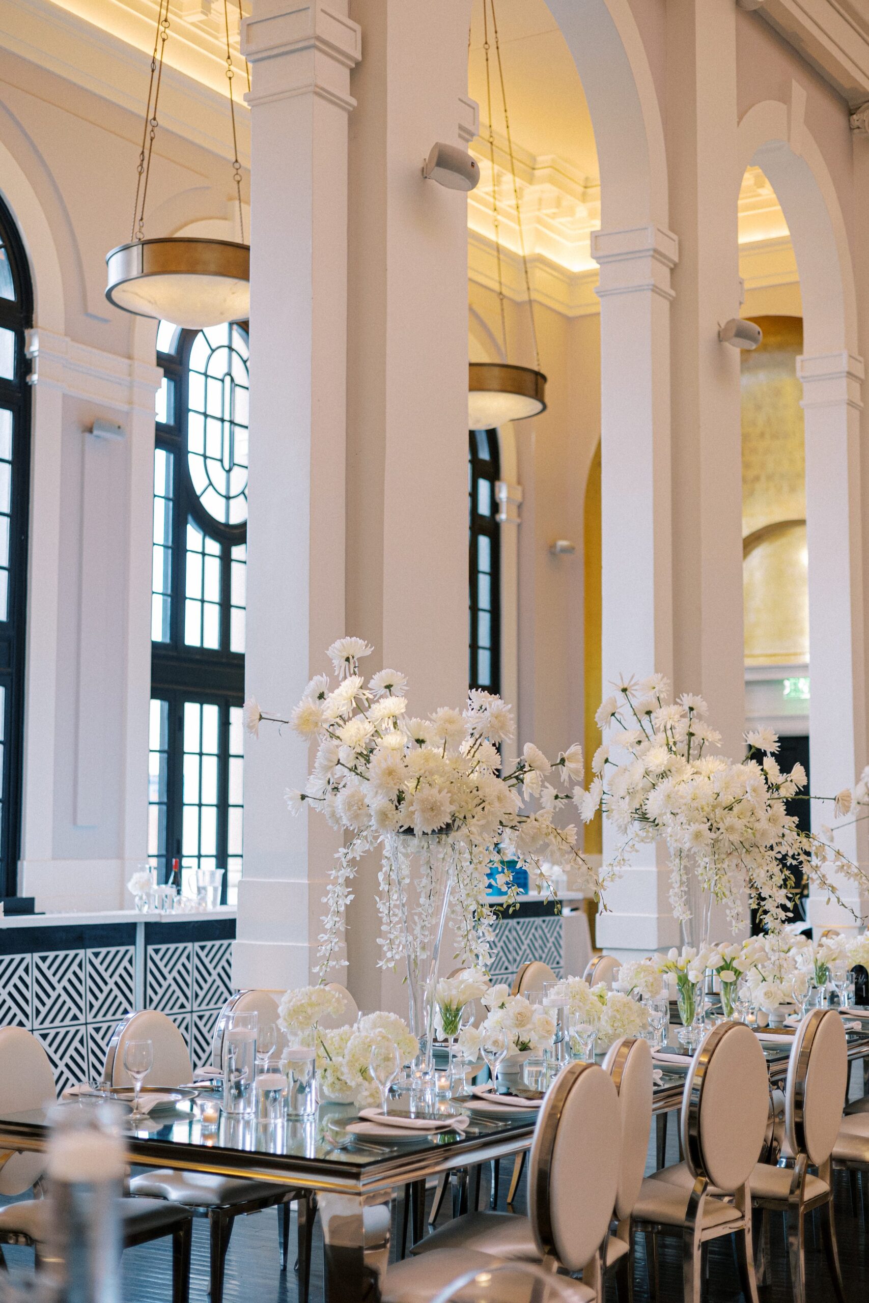 Elevated white floral arrangements and sleek, modern décor adorn the courtyard reception at the Pendry Baltimore, setting an elegant tone for the evening